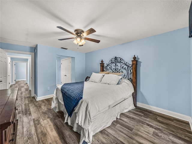 bedroom featuring ceiling fan, a textured ceiling, and dark hardwood / wood-style flooring