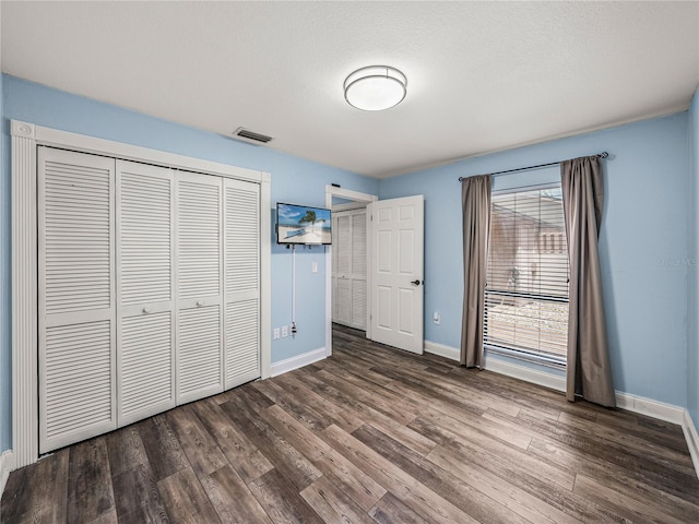 unfurnished bedroom with a closet and hardwood / wood-style flooring