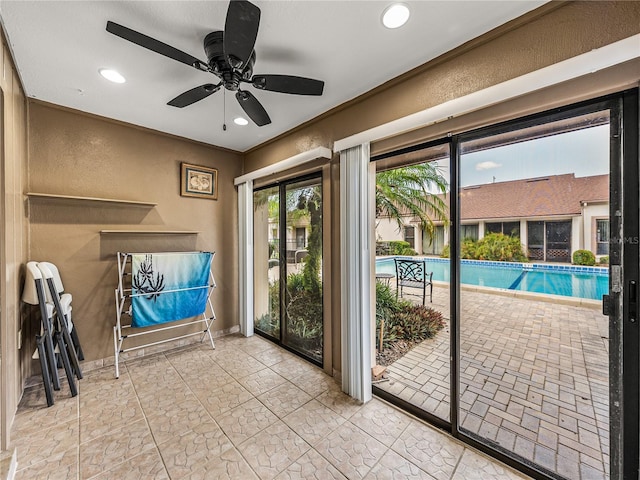 doorway to outside with ceiling fan and light tile patterned floors