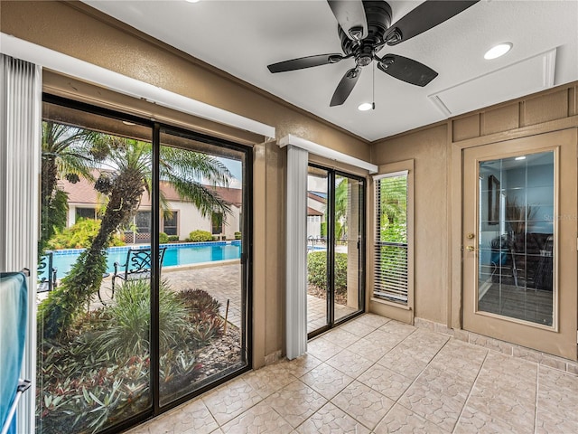 doorway with ceiling fan, light tile patterned flooring, and a wealth of natural light