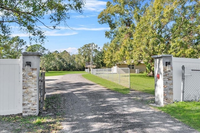 222 Rod Ln, Davenport, FL 33837 - view of dirt / gravel driveway with a gate and a gated entry