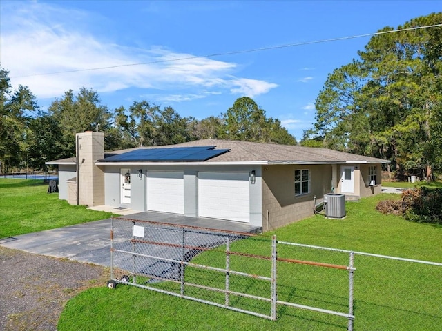 view of front of home featuring a front lawn, solar panels, and central AC