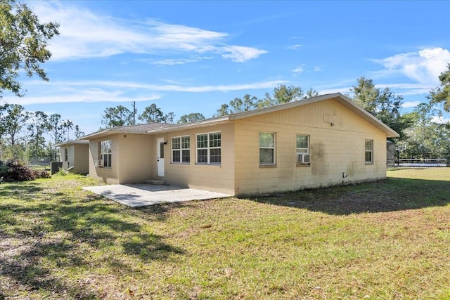 back of house with cooling unit, a yard, and a patio