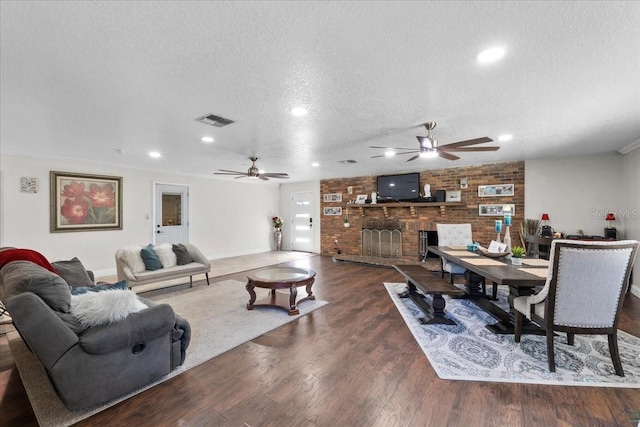 living room with a fireplace, a textured ceiling, and dark wood-type flooring