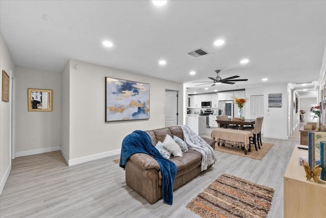 living room featuring ceiling fan and light hardwood / wood-style flooring