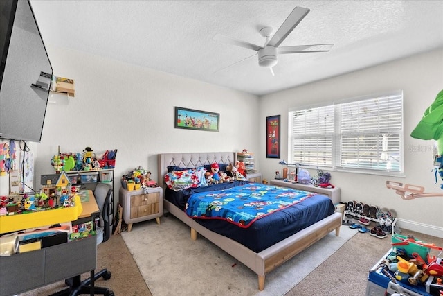 carpeted bedroom featuring ceiling fan and a textured ceiling