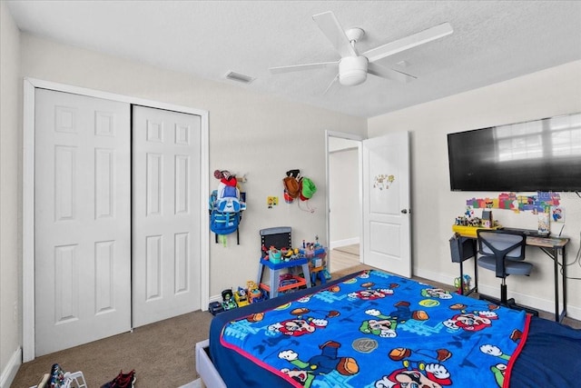 bedroom with ceiling fan, a closet, carpet floors, and a textured ceiling