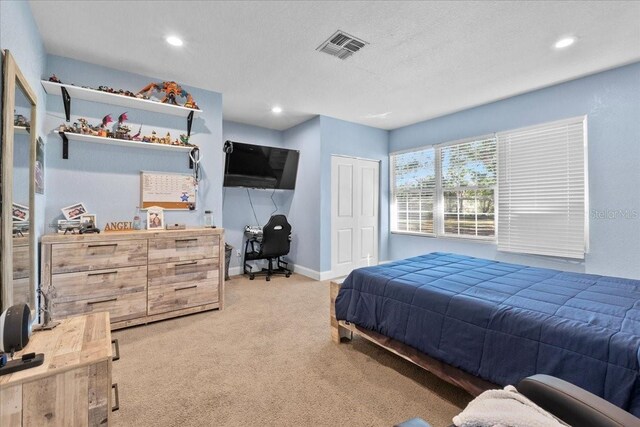 bedroom with light colored carpet and a closet