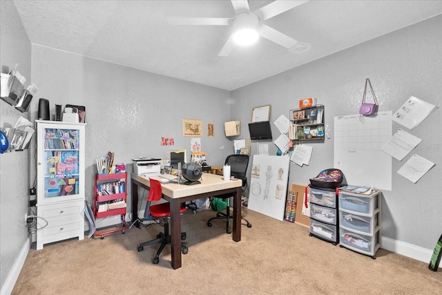 carpeted office space featuring ceiling fan