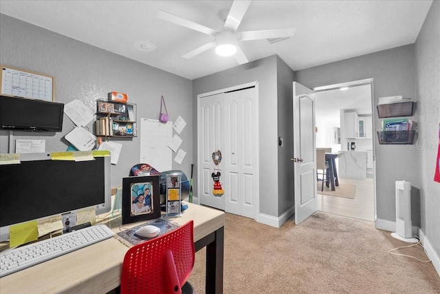 office space featuring light carpet and ceiling fan