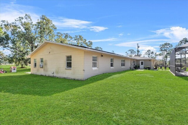 222 Rod Ln, Davenport, FL 33837 - rear view of house with a lawn and a lanai