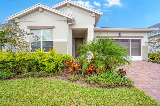 view of front of property with a garage and a front lawn