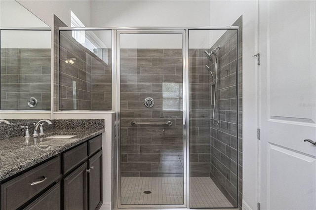 bathroom with a shower with shower door and vanity