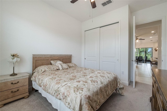 carpeted bedroom with ceiling fan and a closet