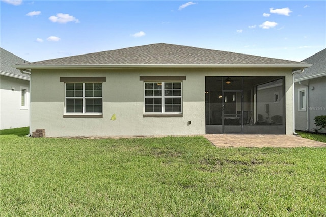 back of property with a yard, a sunroom, and a patio