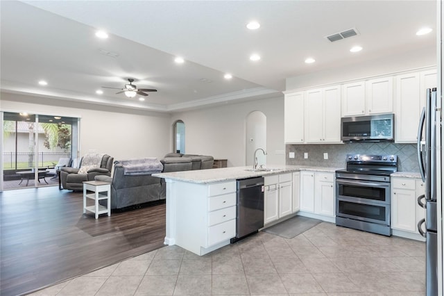 kitchen with white cabinets, sink, light hardwood / wood-style flooring, kitchen peninsula, and stainless steel appliances