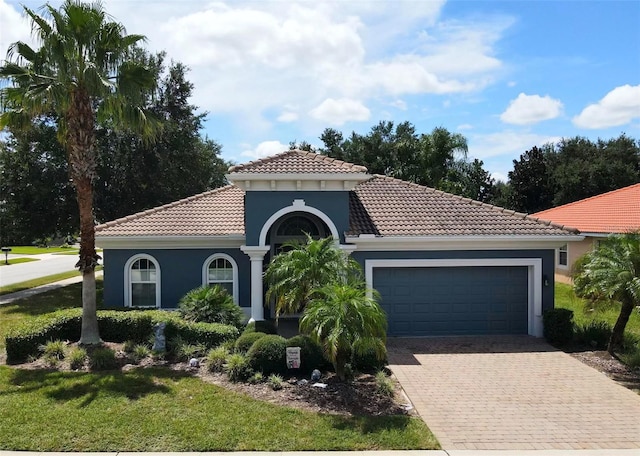 mediterranean / spanish-style house with a garage and a front lawn