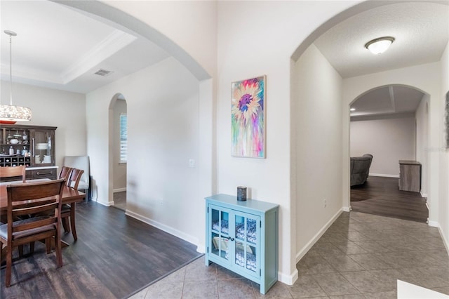 dining area featuring hardwood / wood-style flooring, a textured ceiling, and a tray ceiling