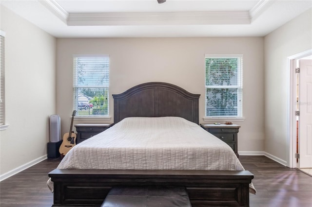 bedroom featuring a raised ceiling, ornamental molding, and dark wood-type flooring