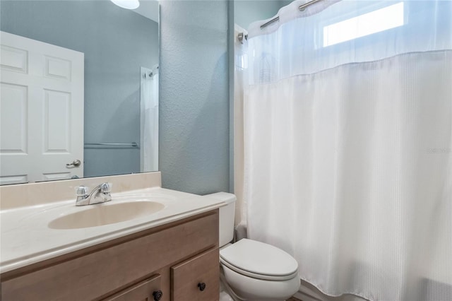 full bathroom with shower / tub combo with curtain, vanity, and toilet