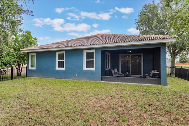 rear view of property featuring a sunroom and a yard