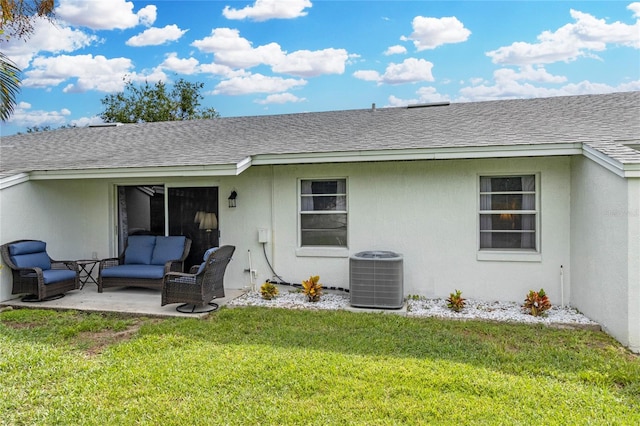 rear view of property with a patio, outdoor lounge area, central air condition unit, and a lawn