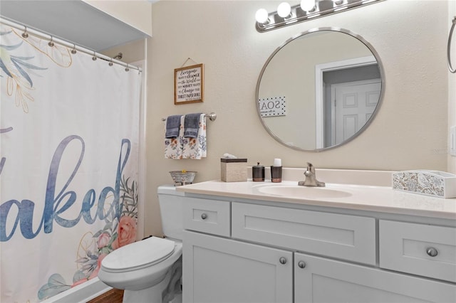 bathroom featuring toilet, curtained shower, and vanity