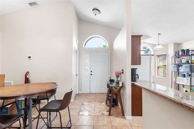 tiled entryway featuring a healthy amount of sunlight and lofted ceiling