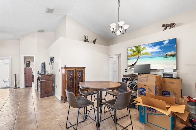 tiled dining area featuring high vaulted ceiling and an inviting chandelier