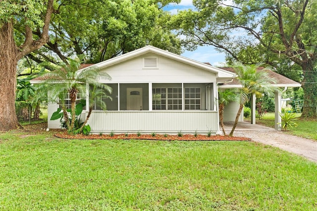 view of front facade featuring a sunroom and a front lawn