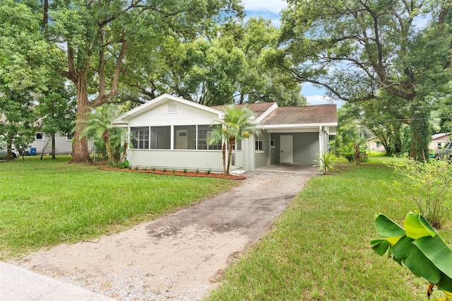 view of front facade with an attached carport, driveway, and a front lawn