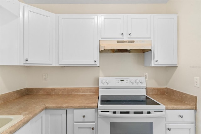 kitchen featuring under cabinet range hood, white electric range oven, white cabinets, and light countertops