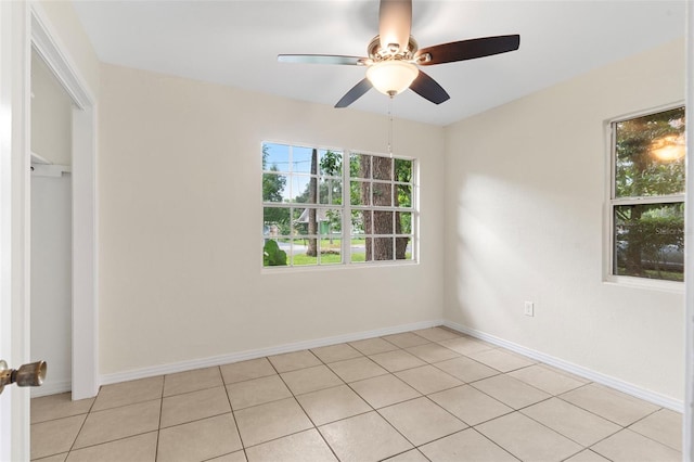 spare room with ceiling fan, baseboards, and light tile patterned floors