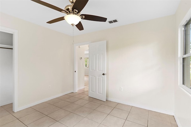 unfurnished bedroom featuring light tile patterned floors, multiple windows, and visible vents