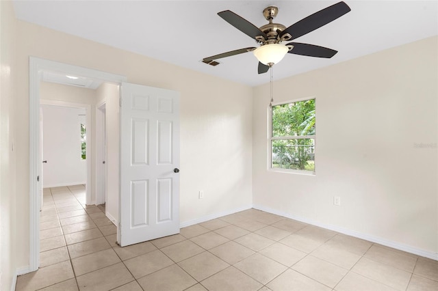 unfurnished room with a ceiling fan, visible vents, baseboards, and light tile patterned floors