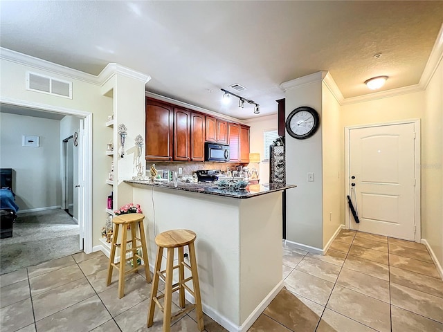 kitchen with light tile patterned flooring, backsplash, ornamental molding, track lighting, and kitchen peninsula