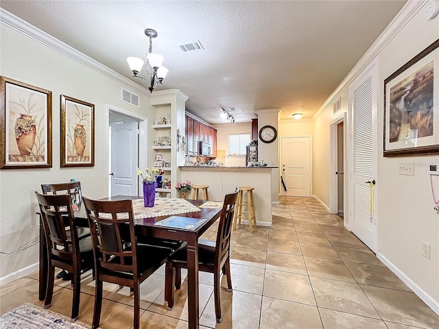902 Charo Pkwy Unit 624, Davenport, FL 33897 - dining room featuring a chandelier, light tile patterned flooring, crown molding, baseboards, and a textured ceiling