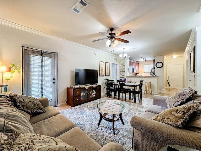 living room featuring crown molding, ceiling fan with notable chandelier, and light tile patterned floors