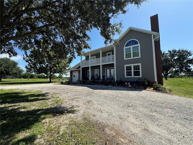 view of front of property featuring a balcony and a front yard