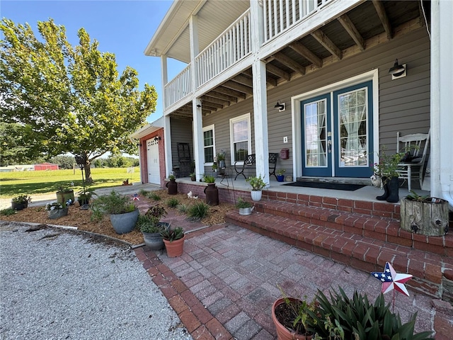 view of patio with a porch, a balcony, and a garage