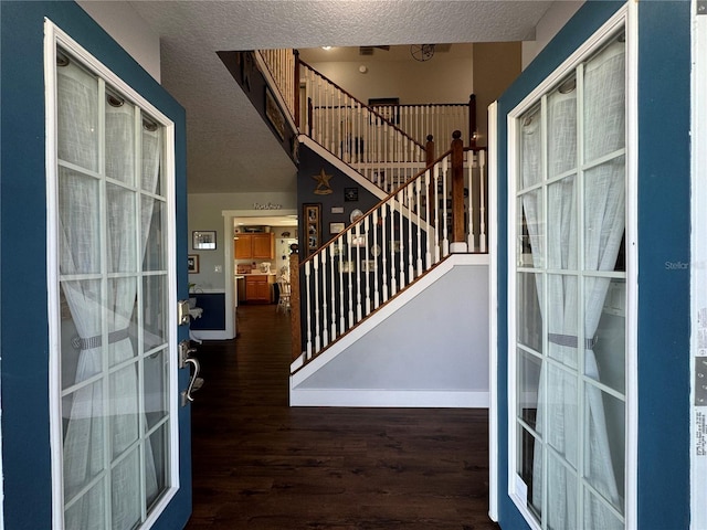 entrance foyer with a textured ceiling and dark hardwood / wood-style flooring