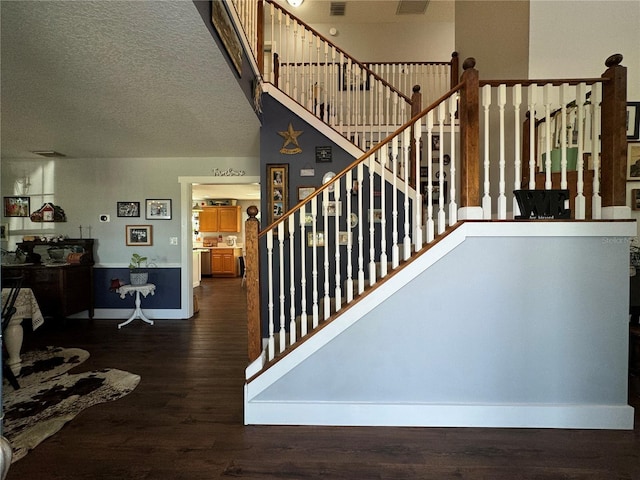 staircase featuring hardwood / wood-style floors and a textured ceiling