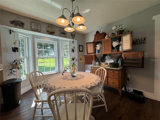 dining area with dark hardwood / wood-style flooring, a textured ceiling, and an inviting chandelier