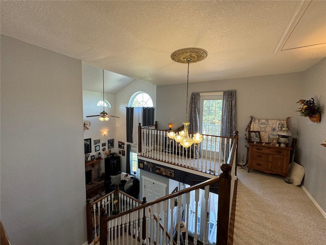 staircase featuring a textured ceiling, carpet floors, vaulted ceiling, and ceiling fan