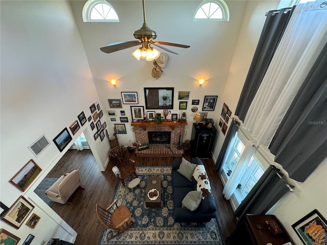 living room with ceiling fan, a healthy amount of sunlight, and a high ceiling