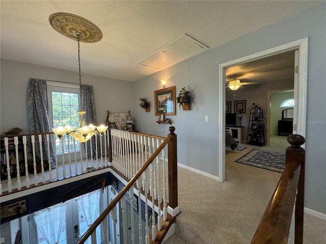 hall with a textured ceiling and carpet floors