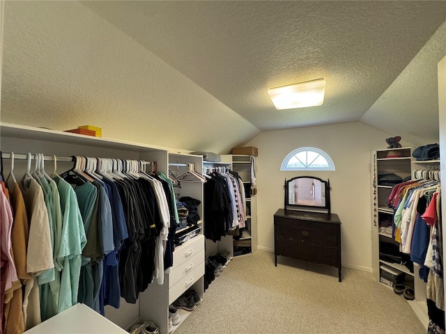 walk in closet featuring carpet floors and vaulted ceiling