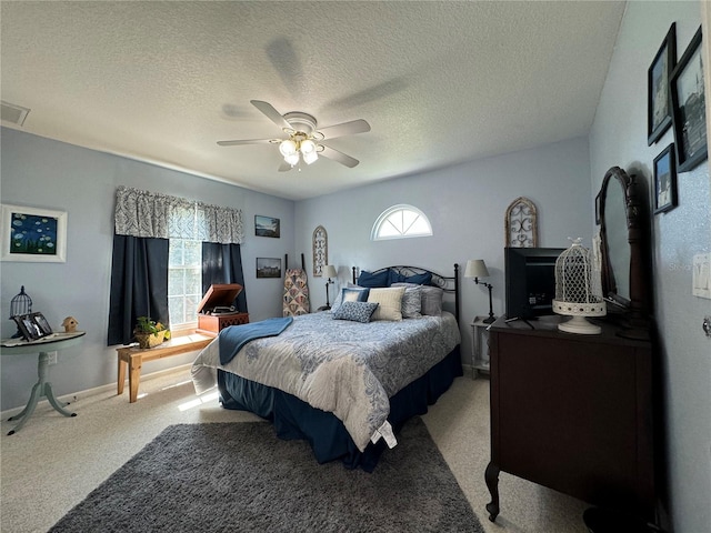 carpeted bedroom featuring ceiling fan, a textured ceiling, and multiple windows