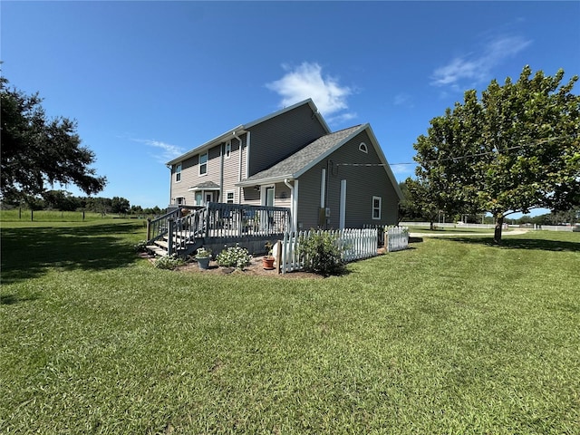 rear view of property featuring a yard and a deck