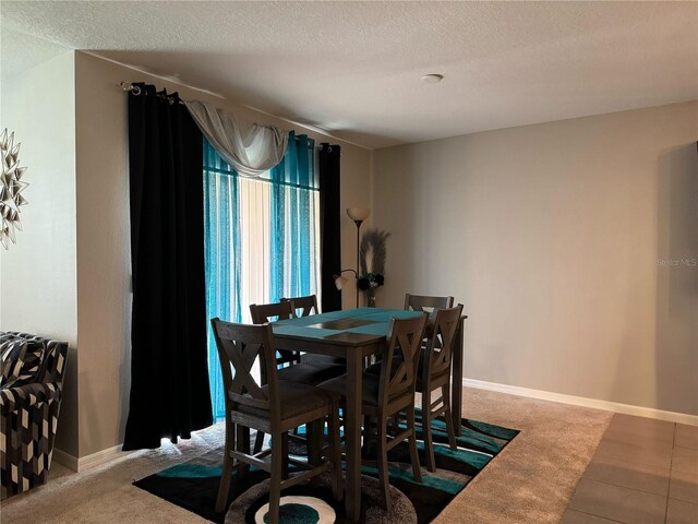 dining room featuring a textured ceiling and tile patterned floors